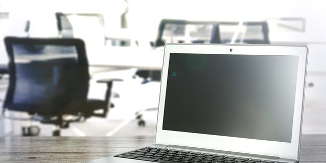 ordinateurs portables posés sur des bureaux pour parler des espaces de travails qui sont un enjeu dans la RSE et la performance des salariés