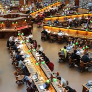 photo d'une grande bibliothèque anglaise avec de longues tables en étoile autour d'un ilot central, des lampes vertes et des étudiants alignés les uns à côtés et en face des autres.... Pour imager la concentration